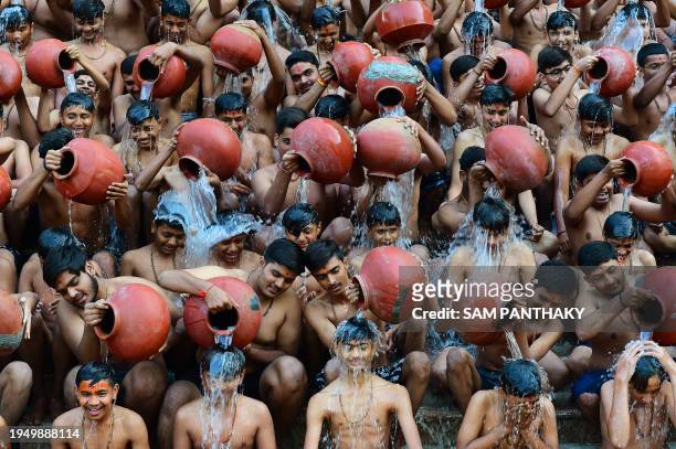 Students from the Swaminarayan Gurukul school take part in a 'Magh Snan' or holy bath in Ahmedabad on January 24, 2024.