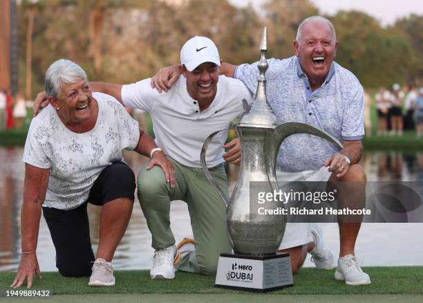 Rory McIlroy of Northern Ireland laughs with his parents, Rosie and Gerry McIlroy as they pose with the trophy after the final round of the Hero...