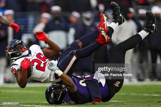 Justin Madubuike of the Baltimore Ravens tackles Devin Singletary of the Houston Texans during the first quarter in the AFC Divisional Playoff game...