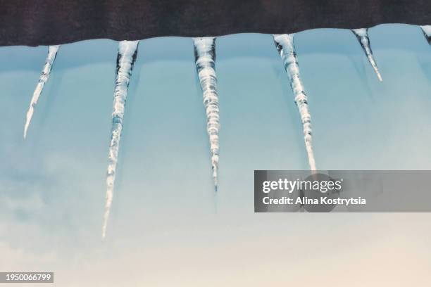 icicles hanging on roof in winter - shaking hangs stock pictures, royalty-free photos & images