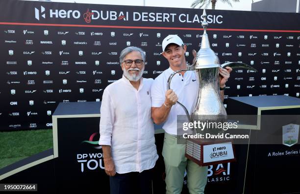 Rory McIlroy of Northern Ireland poses with the Hero Dubai Desert Classic trophy with Dr Pawan Munjal the Chairman and The CEO of The Hero MotoCorp...