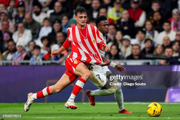 Vinicius Junior of Real Madrid CF battles for the ball with Marc Pubill of UD Almeria during the LaLiga EA Sports match between Real Madrid CF and UD...