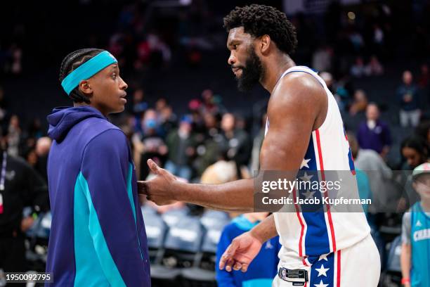 Joel Embiid of the Philadelphia 76ers talks with Frank Ntilikina of the Charlotte Hornets after their game at Spectrum Center on January 20, 2024 in...