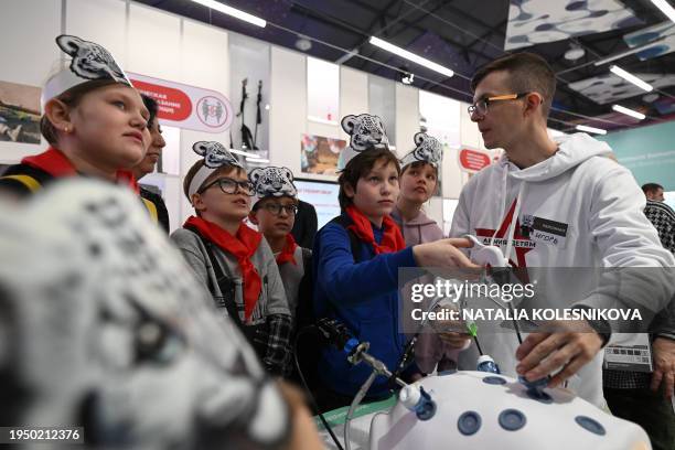 Children take part in a first aid training while touring the Russian Defence Ministry pavilion at Russia Expo, an exhibition designed to demonstrate...