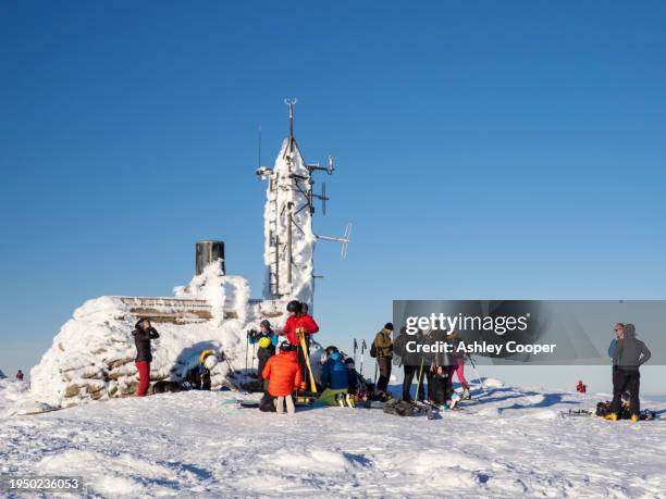 ski mountaineers by the automatic weather station on the summit of cairngorm in the cairngorms, scotland, uk - cairngorms skiing stockfoto's en -beelden