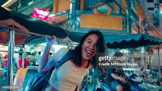 junge asiatische touristin, die mit einem tuk-tuk-fahrzeug auf der straße in bangkok, thailand, unterwegs ist. urlaubsreise. - bangkok stock-fotos und bilder