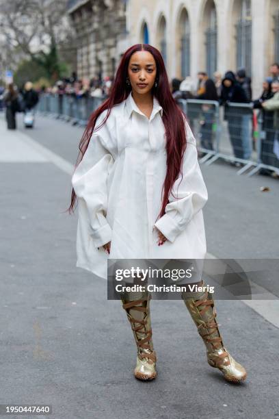 Rimon wears white coat, laced knee high golden boots outside Sacai during the Menswear Fall/Winter 2024/2025 as part of Paris Fashion Week on January...