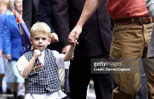 Riley Hughes marches with his father through the streets of Brisbane April 25, 2003 during the annual Anzac Day parade in Brisbane, Australia. Anzac...