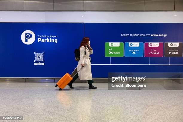 Traveler wheels luggage past an official airport parking sign at Athens International Airport SA in Athens, Greece, on Wednesday, Jan. 24, 2024....