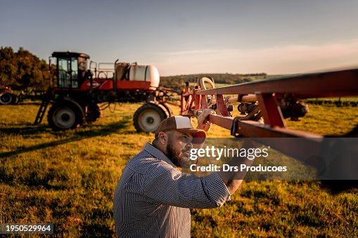Farmer checking agricultural machinery parts Farmer checking agricultural machinery parts