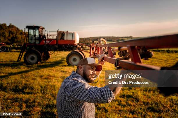 farmer checking agricultural machinery parts - jordbruksutrustning bildbanksfoton och bilder