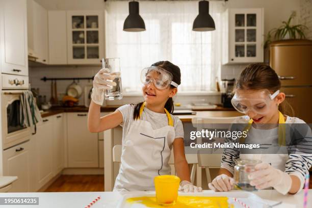 duas meninas se divertindo fazendo experimentos em casa - atividade - fotografias e filmes do acervo