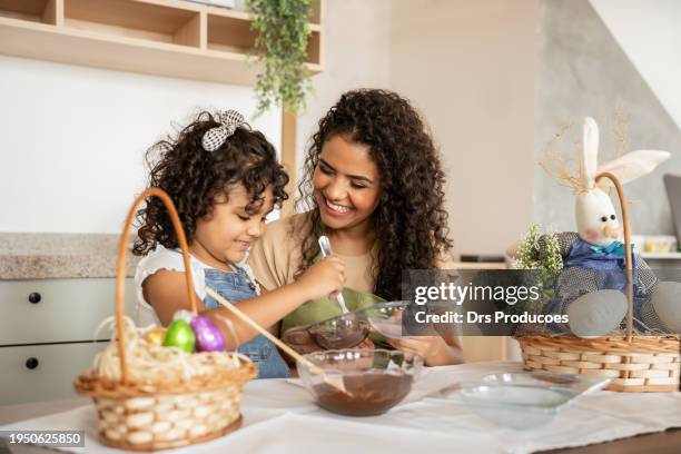 mother and daughter making chocolate eggs for easter - happy easter mom stock pictures, royalty-free photos & images