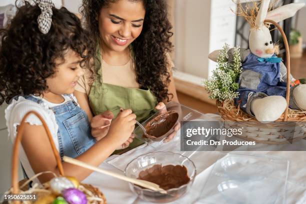 mother and daughter making chocolate eggs for easter - easter egg chocolate stock pictures, royalty-free photos & images