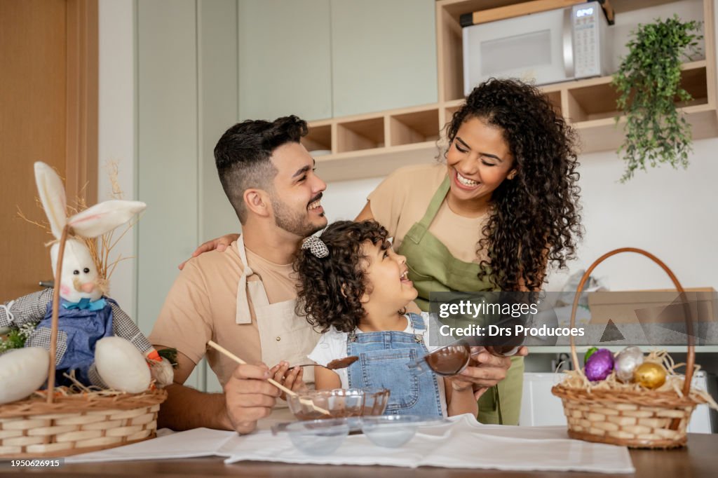 Family with a daughter making chocolate for Easter
