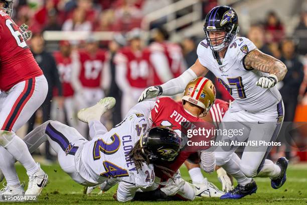 Brock Purdy of the San Francisco 49ers battles with Jadeveon Clowney and Brent Urban of the Baltimore Ravens in action during a game between the San...