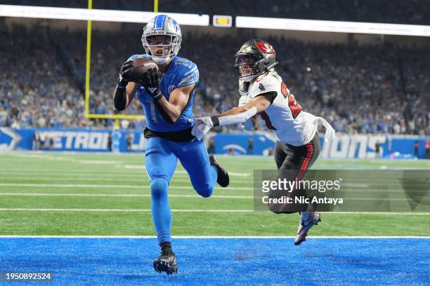 Amon-Ra St. Brown of the Detroit Lions catches a pass for a touchdown in front of Zyon McCollum of the Tampa Bay Buccaneers during the fourth quarter...