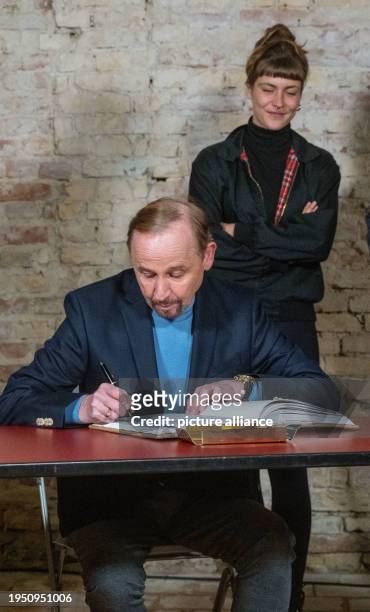 January 2024, Mecklenburg-Western Pomerania, Stralsund: Actors Alexander Held and Sophie Pfennigstorf signing the guest book of the town of...