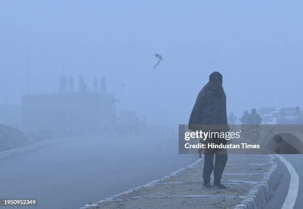 Commuters brave the early morning winter fog and chill as they cross Railway crossing in Dwarka in South West Delhi, on January 24, 2024 in New...