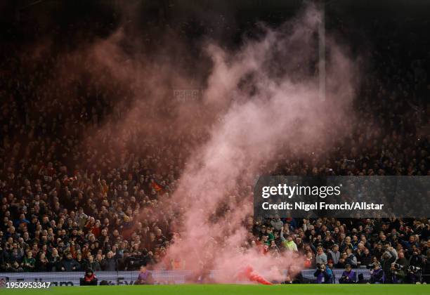 Flare is thrown on the pitch during the Carabao Cup Semi Final Second Leg match between Fulham and Liverpool at Craven Cottage on January 24, 2024 in...