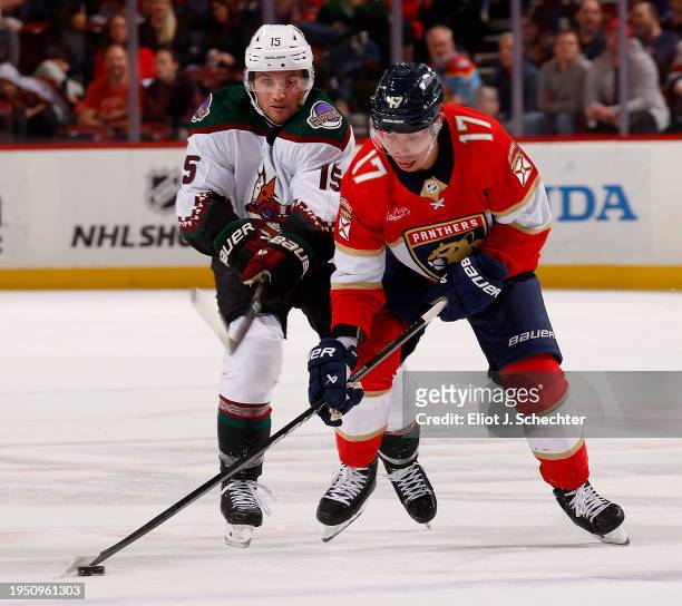 Evan Rodrigues of the Florida Panthers skates with the puck against Alex Kerfoot of the Arizona Coyotes at the Amerant Bank Arena on January 24, 2024...