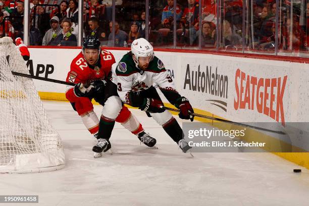 Michael Carcone of the Arizona Coyotes skates for possession against Brandon Montour of the Florida Panthers at the Amerant Bank Arena on January 24,...