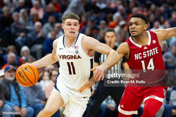 Isaac McKneely of the Virginia Cavaliers drives past Casey Morsell of the NC State Wolfpack in the second half during a game at John Paul Jones Arena...