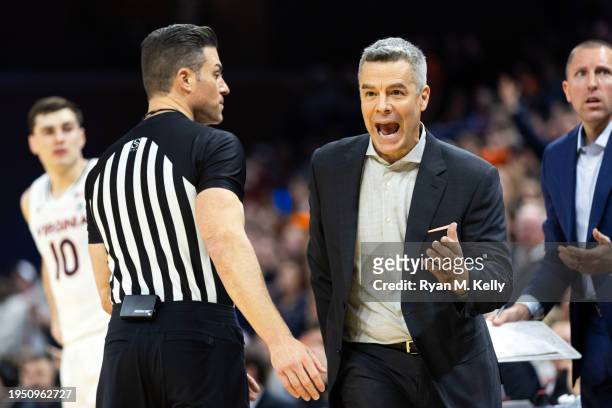 Head coach Tony Bennett of the Virginia Cavaliers reacts to a play beside referee Lee Cassell in the second half during a game against the NC State...
