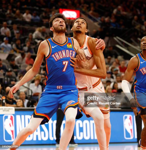 Chet Holmgren of the Oklahoma City Thunder fights for rebounding position with Victor Wembanyama of the San Antonio Spurs in the first half at Frost...