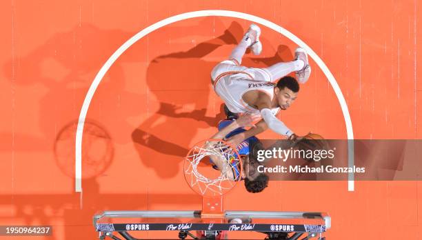 Victor Wembanyama of the San Antonio Spurs and Chet Holmgren of the Oklahoma City Thunder drive to the basket during the game on January 24, 2024 at...