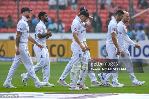 England's players walk off the field after the national anthem before the start of the first day of the first Test cricket match between India and...