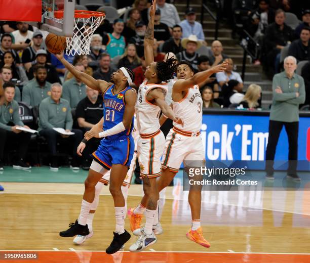 Aaron Wiggins of the Oklahoma City Thunder drives to the basket against Devin Vassell of the San Antonio Spurs in the second half at Frost Bank...