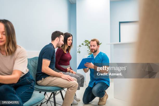 ultraschallgespräch eines paares mit einem männlichen krankenpfleger - ordination stock-fotos und bilder