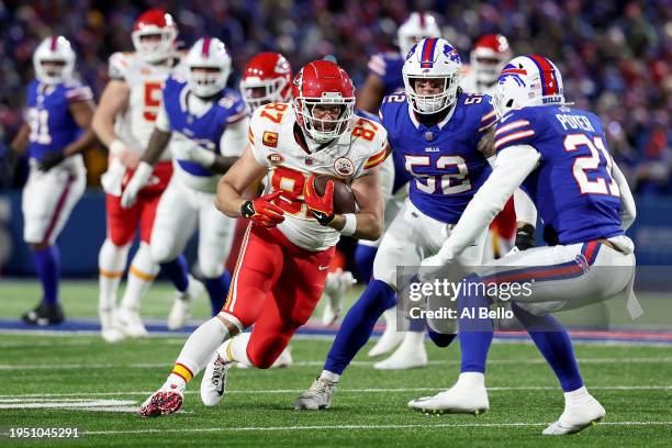 Travis Kelce of the Kansas City Chiefs runs with the ball after a reception against A.J. Klein and Jordan Poyer of the Buffalo Bills during the first...