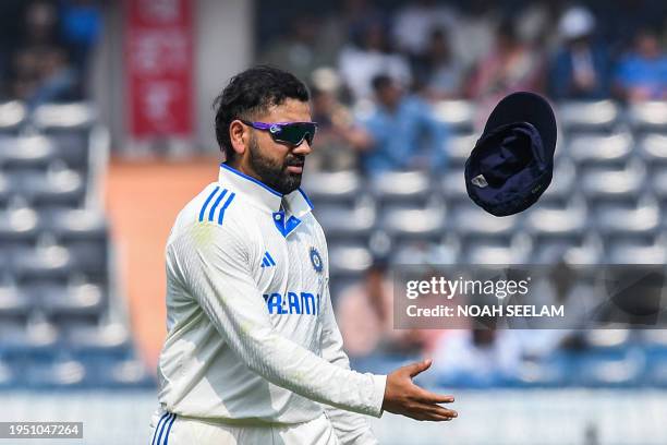 India's captain Rohit Sharma tosses his cap during the first day of the first Test cricket match between India and England at the Rajiv Gandhi...