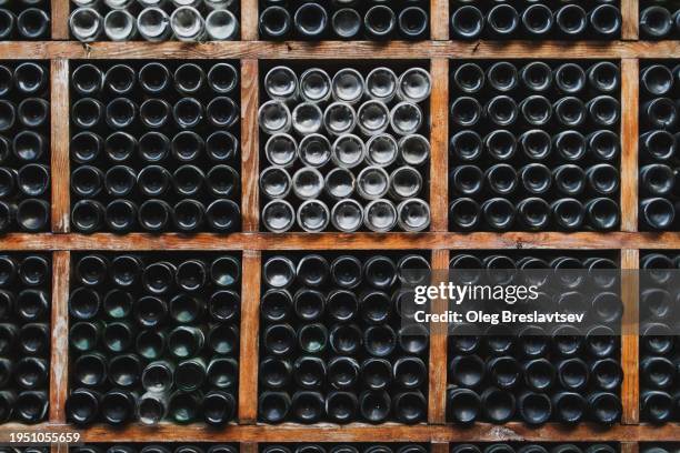 background of empty wine bottles in wine cellar - flaschenpost stock-fotos und bilder