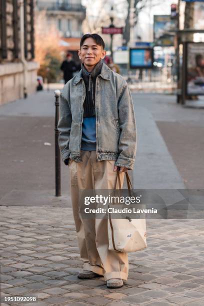 Guest wears denim jacket, beige pants, Loewe bag, outside Loewe, during the Menswear Fall/Winter 2024/2025 as part of Paris Fashion Week on January...