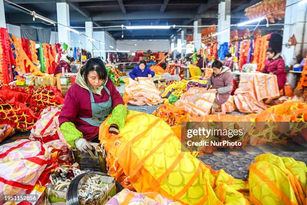 Workers are threading steel wires for a dragon lantern at a production workshop in Nanchang, Jiangxi Province, China, on January 24, 2024.