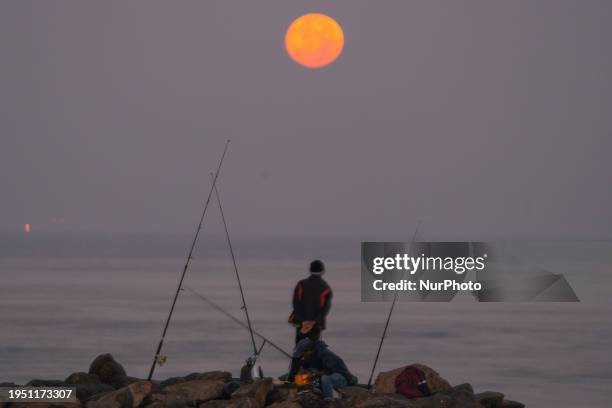 Fisherman is fishing under the light of the Wolf Moon in Colombo, Sri Lanka, on January 25, 2024. The Wolf Moon is the name often given to the full...