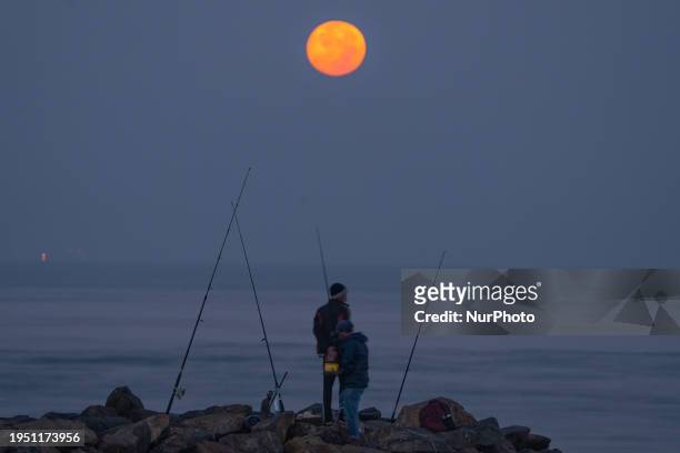 Fisherman is fishing under the light of the Wolf Moon in Colombo, Sri Lanka, on January 25, 2024. The Wolf Moon is the name often given to the full...