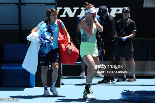 Elina Svitolina of Ukraine walks off court after retiring in their round four singles match against Linda Noskova of Czech Republic during the 2024...