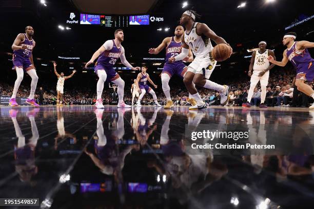 Buddy Hield of the Indiana Pacers handles the ball ahead of Eric Gordon and Jusuf Nurkic of the Phoenix Suns during the second half of the NBA game...