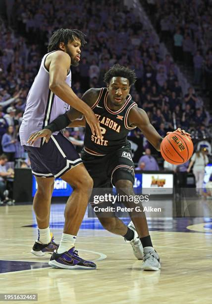 Eric Dailey Jr. #2 of the Oklahoma State Cowboys dribbles the ball against Will McNair Jr. #13 of the Kansas State Wildcats in the first half at...