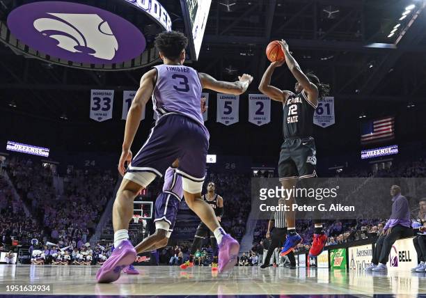 Javon Small of the Oklahoma State Cowboys put up a shot against Dorian Finister of the Kansas State Wildcats in the first half at Bramlage Coliseum...