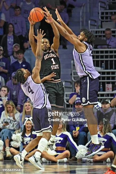 Bryce Thompson of the Oklahoma State Cowboys passes the ball against pressure from Dai Dai Ames and Will McNair Jr. #13 of the Kansas State Wildcats,...