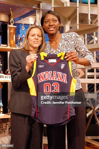 Gwen Jackson, right, holds up her new jersey after being selected by the Indiana Fever during the 2003 WNBA draft on April 25, 2003 in Secaucus, New...