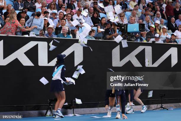 Ball kids clean up paper that was thrown onto Margaret Court Arena by a protestor during the round four singles match between Alexander Zverev of...