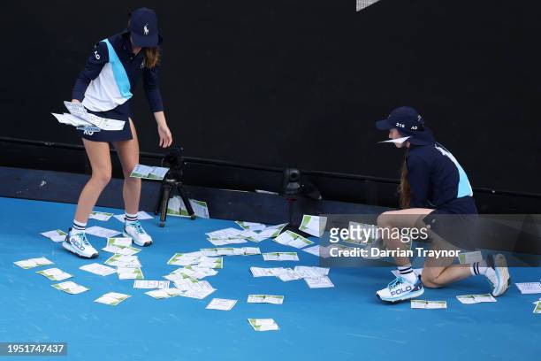 Ball kids clean up paper that was thrown onto Margaret Court Arena by a protestor during the round four singles match between Alexander Zverev of...