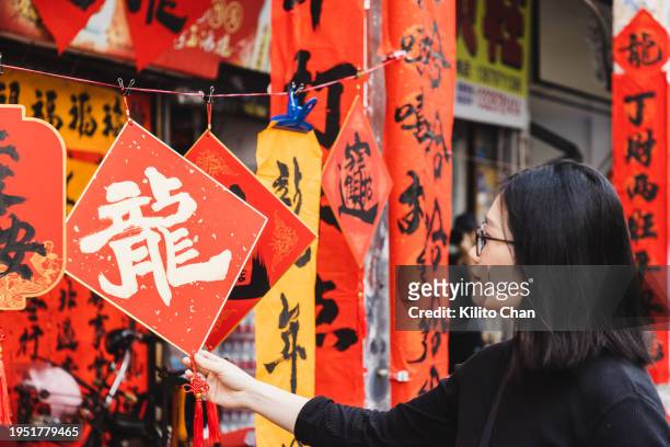 asian woman shopping for chinese new year decorations in new year's market - china tourist stock pictures, royalty-free photos & images