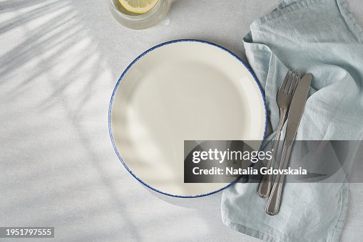 Clean empty white plate, fork and knife on pastel grey table. Concept for menu with utensil Clean empty white plate, fork and knife on pastel grey table. Concept for menu with utensil